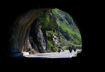 three person riding motorcycle about to enter tunnel during daytime thumbnail