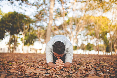 man in white long-sleeved shirt kneeling during daytime photo thumbnail