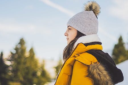 woman in yellow bubble jacket under blue sky thumbnail