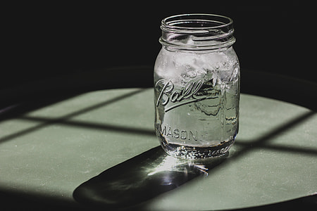 clear glass mason jar on grey table thumbnail