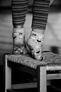 toddler standing on brown rush-seat stool thumbnail