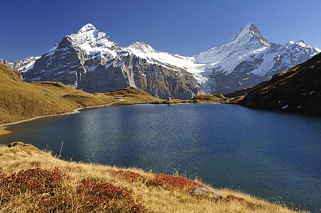 blue body of water in front of mountains thumbnail