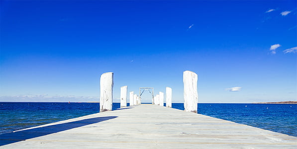 gray concrete dock surrounded by water under blue sky thumbnail