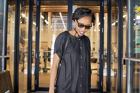 selective focus photography of woman in front of rotating entrance door thumbnail