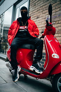 man sitting on red motor scooter thumbnail