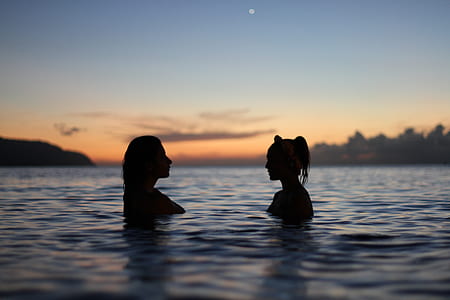 silhouette of two women soaked in body of water thumbnail