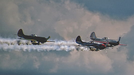 three biplanes flying while releasing smokes thumbnail