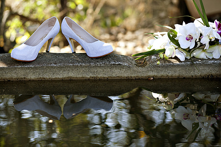 pair of white heeled shoes on gray concrete surface thumbnail