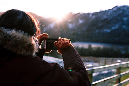 person holding smartphone capturing scene thumbnail