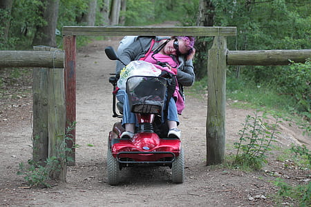 person riding on mobility scooter passing through fence thumbnail