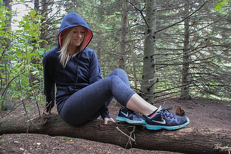 woman wearing hoodie sitting on tree log thumbnail