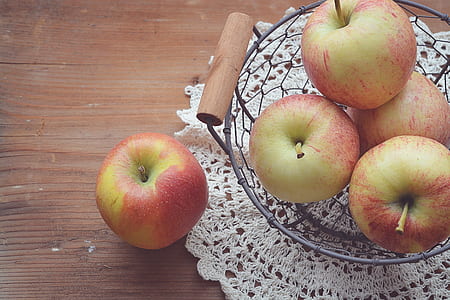four apples on black mesh bowl thumbnail