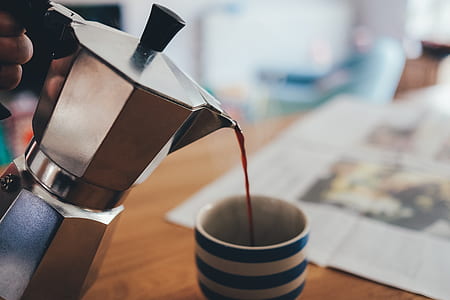 person holding moka pot pouring red liquid on cup thumbnail