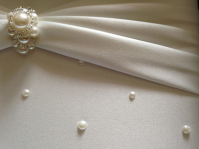 white pearl and silver ribbon on white surface thumbnail