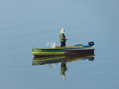 man standing on brown and blue boat thumbnail