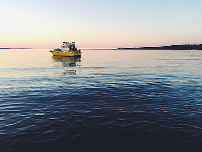 yellow and white boat on calm water during daytime thumbnail
