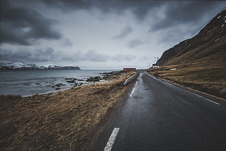asphalt road near body of water thumbnail
