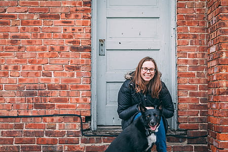 woman with dog beside a door and shingle wall thumbnail