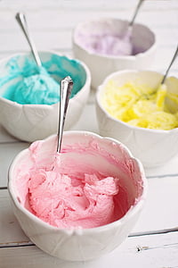 pink, purple, teal, and yellow ice creams on white ceramic bowls with four stianless steel spoons thumbnail