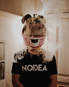 man in black crew-neck t-shirt wearing white and red helmet with smoke thumbnail