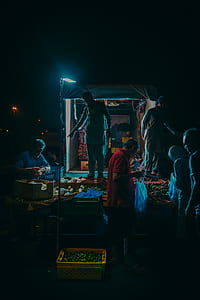 man standing on stall with fruits and vegetable display pointing at another person holding the display thumbnail