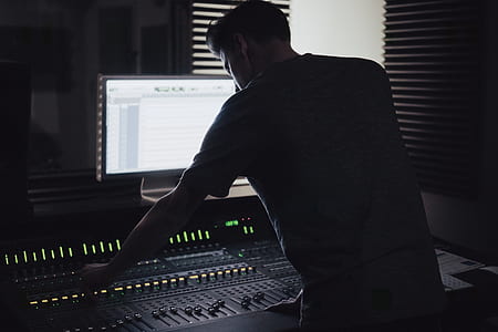 man playing audio mixer in front of flat screen monitor turned on thumbnail