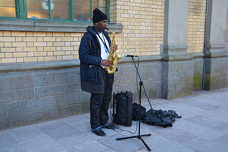man plays saxophone on street thumbnail