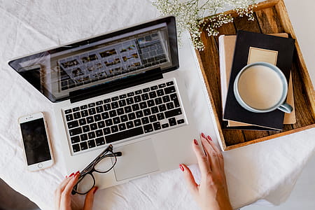 A woman works at a desk with a laptop and a cup of coffee thumbnail