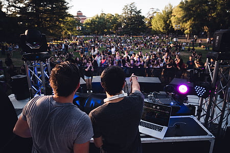 two men on stage with people watching at daytime thumbnail