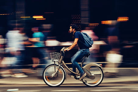 Man Riding Bicycle on City Street thumbnail