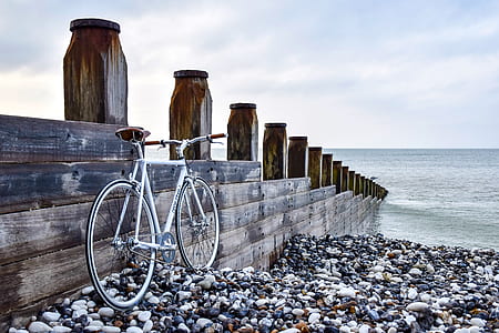 white hardtail bicycle beside brown and black wooden dock thumbnail