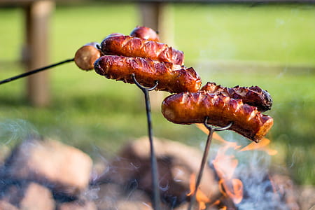 sausages on metal grilling fork thumbnail