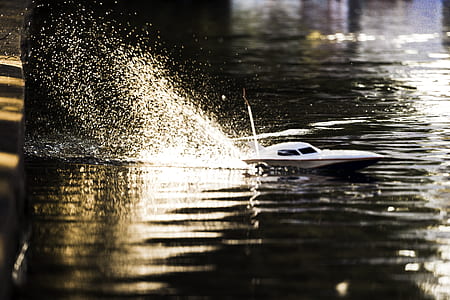 white R/C power boat on body of water thumbnail