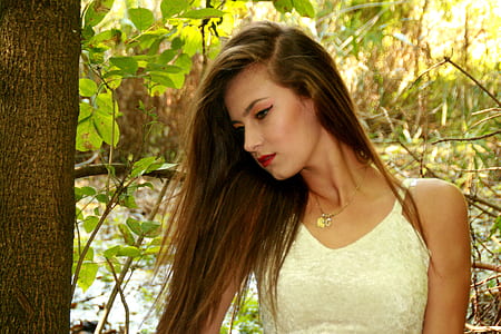 woman standing beside tree thumbnail
