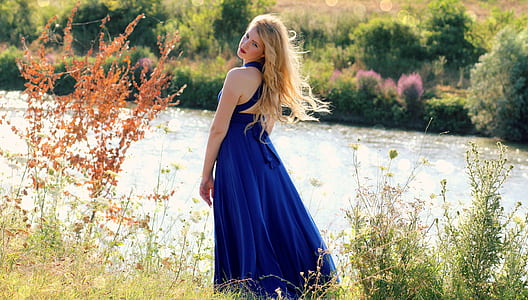 woman standing beside large body of water during daytime thumbnail