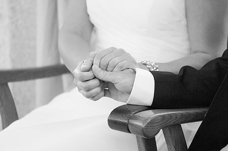 grayscale photography of groom and bride holding their hands together thumbnail