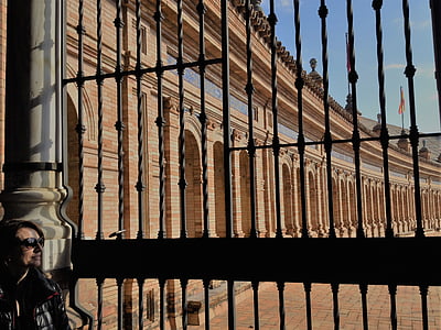 woman standing beside gate near beige gothic palace thumbnail