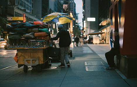 man pushing cart with accessories on sidewalk thumbnail