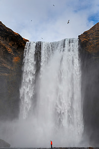 man standing near falls during day time thumbnail