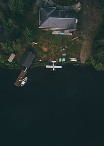 aerial photography of biplane passing through house thumbnail