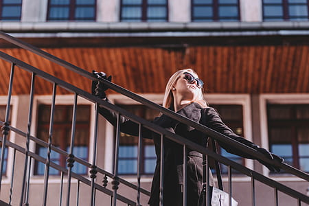 selective focus photo of a woman holding stair railings thumbnail
