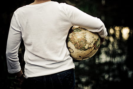 man wearing white long-sleeved shirt carrying globe thumbnail