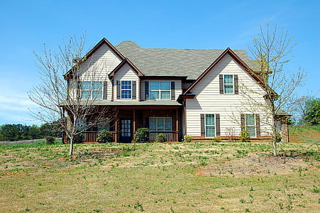 white and gray painted house in the middle of grass field thumbnail