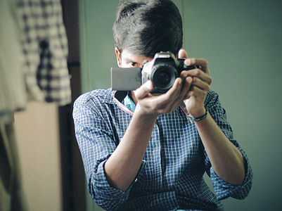 man holding black DSLR camera thumbnail