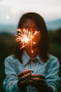 shadow depth of field photography of woman holding sparklers thumbnail