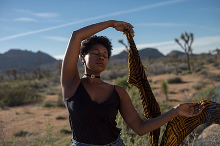 woman holding brown and black shawl thumbnail