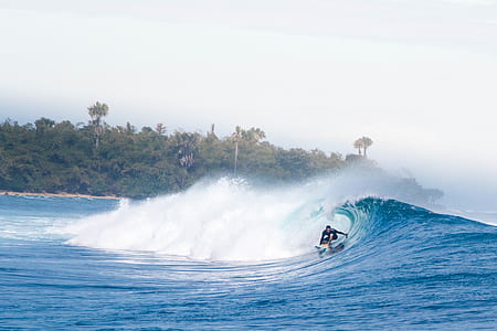 person surfing on body of water during daytime thumbnail