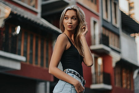 woman wearing black camisole and gray denim jeans standing while looking on back thumbnail