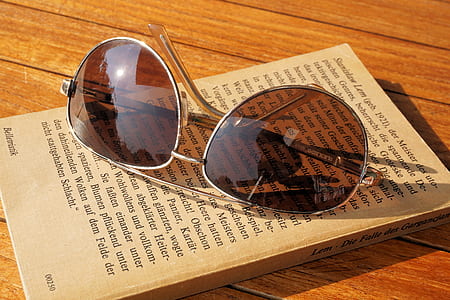 Silver Steel Framed Aviator Sunglasses on Top of Book during Daytime thumbnail