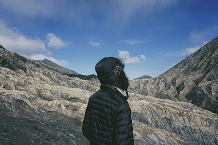 person wearing black bubble hoodie on rocky mountain hill during daytime thumbnail